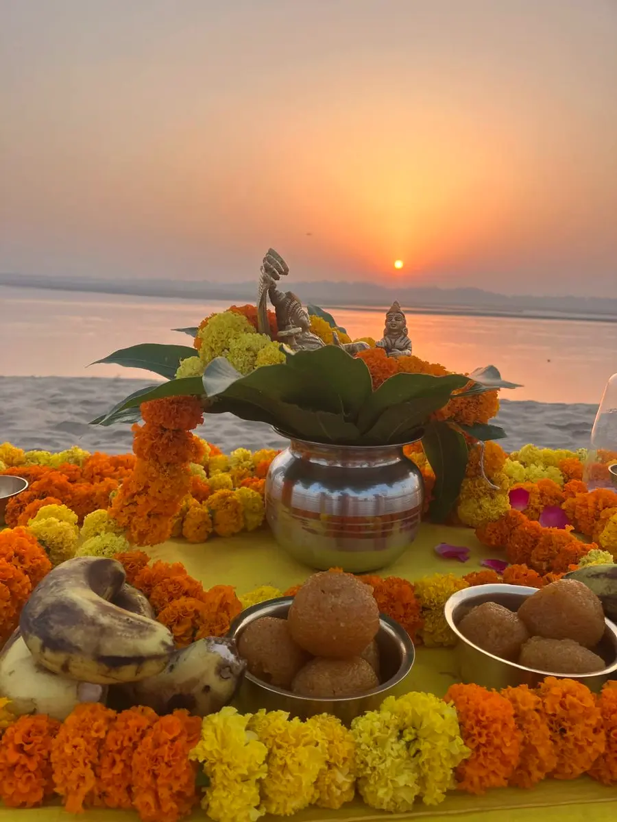 A devotional altar with kalash and marigold offerings at sunset